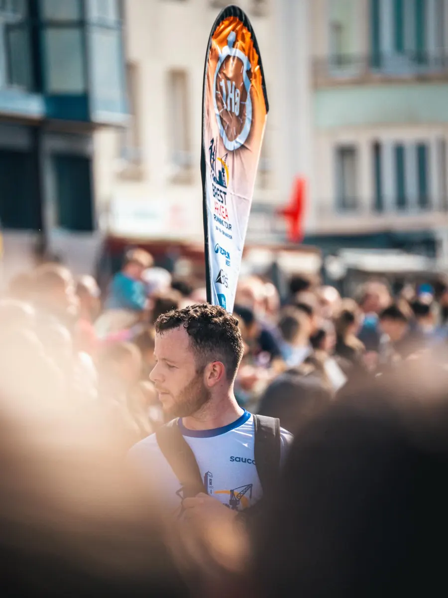 Un meneur d'allure 1h45 du Brest Arkéa Running Tour, drapeau au-dessus de la foule